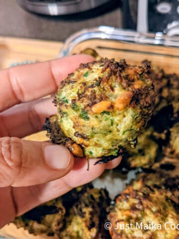 author's hand holding up a cooked turkey meatball